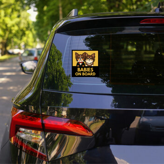 Car with 'Babies on Board' sticker featuring two dogs on a black vehicle.